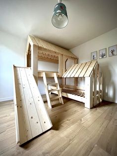 a room with bunk beds and stairs in the middle, on top of hard wood flooring