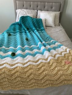 a crocheted blanket sitting on top of a bed