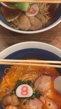 two bowls of ramen with chopsticks on the side