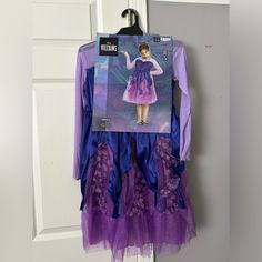 a purple and blue dress hanging from a hook on a door hanger in front of a white door