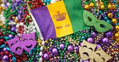 mardi gras decorations, masks and beads are on the ground with a flag