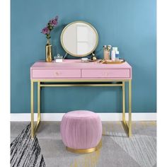 a pink vanity with gold legs and a round mirror on the wall next to it