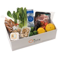 a white box filled with lots of different types of vegetables and meats next to tomatoes