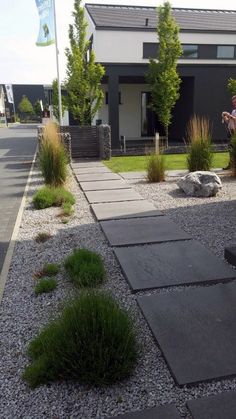 a walkway in front of a house with grass and rocks