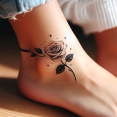 a woman's foot with a rose tattoo on the side of her leg,