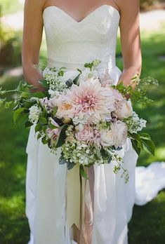 a bride holding a bouquet of flowers in her hands