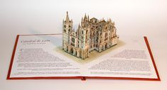 an open book with a model of a cathedral on it