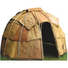 a large brown tent sitting on top of a lush green field