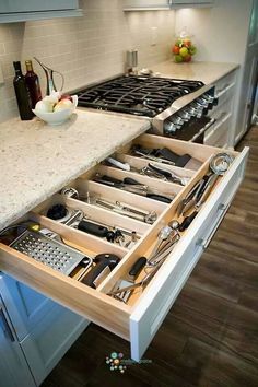 an open drawer in a kitchen filled with utensils