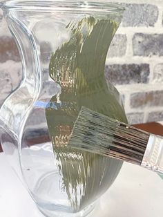 a glass vase with some paintbrushes in it