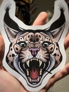 a person holding up a sticker with an image of a leopard's head