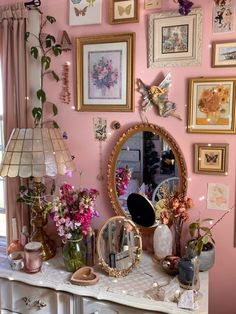 a dresser with flowers and pictures on the wall