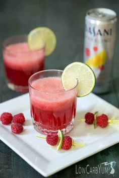 raspberry lemonade cocktail with limes and strawberries on a white plate