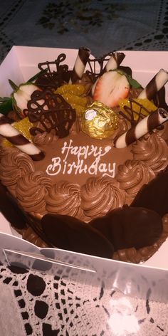 a birthday cake with chocolate frosting and strawberries in the shape of a heart