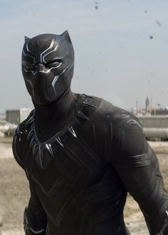 a man dressed as black panther standing in front of an airplane