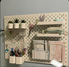 a white peg board with some office supplies on it