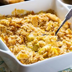 a casserole dish with bread crumbs in it and a serving spoon