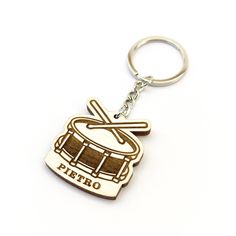 a metal keychain with a drum on it