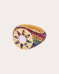 Based in solid 18-karat gold, this statement ring decorates its tapered band with a rainbow-hued array of genuine gemstones. The circular face features a sun motif created from inlaid mother of pearl for iridescent appeal. From L'Atelier Nawbar’s Cosmic Love Collection, inspired by the heavenly bodies that adorn our skies, sun, moon, horoscopes, constellations and zodiac signs. 18k yellow gold, mother of pearl, emerald, yellow sapphire, orange sapphire, blue sapphire, pink sapphire, ruby, blue t Pink Saphire, Sun Motif, Cosmic Love, Family Ring, Heavenly Bodies, Rainbow Ring, Turtle Dove, Family Rings, High Jewellery