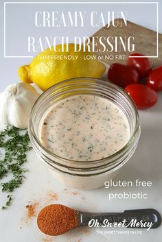 a jar filled with ranch dressing next to tomatoes and garlic