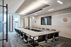 an empty conference room with white walls and black chairs