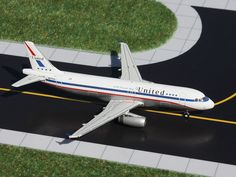 a model airplane is sitting on the tarmac in front of grass and yellow lines