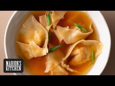 a white bowl filled with dumplings covered in broth