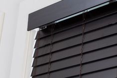 the blinds are closed on the outside of the window, which is covered with black cording