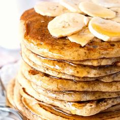 a stack of pancakes topped with bananas and syrup