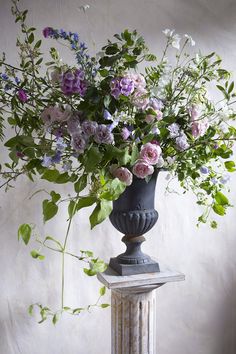 a vase filled with lots of flowers sitting on top of a table