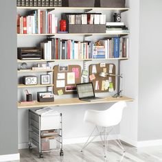 a laptop computer sitting on top of a desk in front of a bookshelf