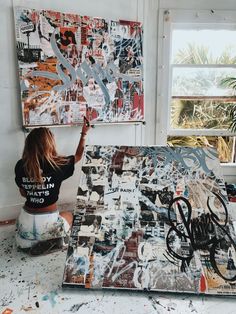 a woman sitting on the floor next to an art work