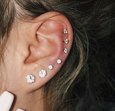 a close up of a person's ear with small flowers on the top of it