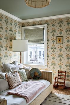 a living room filled with furniture and wallpaper next to a window covered in curtains