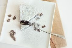 a piece of cake on a white plate with a fork sticking out of the top