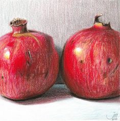 two red pomegranates sitting next to each other