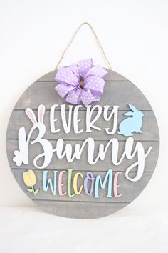 a wooden sign that says every bunny welcome with a bow on the front and side