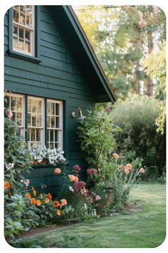 a green house with lots of flowers in the front yard