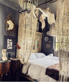 an old fashioned bedroom is decorated in white and beige colors, with sheer curtains hanging from the ceiling