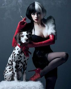 a woman in black dress and red gloves sitting next to a dalmatian