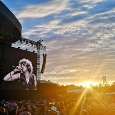 a large crowd is watching an outdoor concert