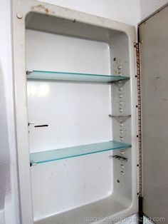 an old white refrigerator with glass shelves in it