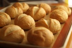 rolls are lined up on a baking sheet