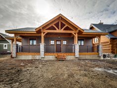 a house that is in the middle of some dirt and has two porches on it