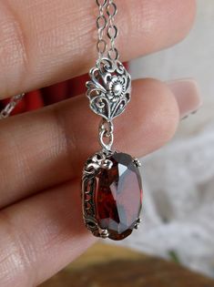 garnet pendant, with a deep red oval stone set in floral sterling silver filigree, 4 prongs hold the gem in place Edwardian Necklace, Antique Filigree, Filigree Necklaces, Filigree Jewelry, Garnet Pendant, Cz Pendant, Sterling Silver Filigree, Pendant Design, Silver Filigree