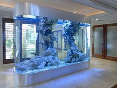 a large aquarium with rocks and water in the middle on display at a home's entrance