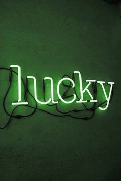 a neon sign that reads lucky on the side of a wall with wires attached to it