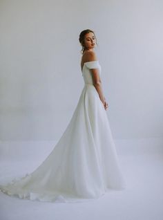 a woman in a white wedding dress posing for a photo with her hands on her hips