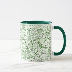 a green and white coffee mug sitting on top of a table