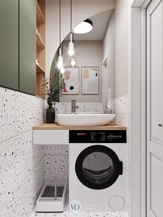 a washer and dryer in a small room with lights on the ceiling above